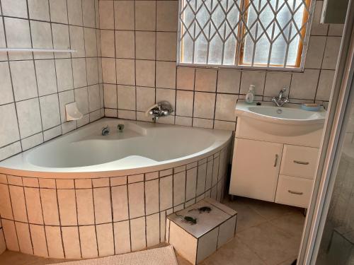 a bathroom with a tub and a sink at Ben Kalulu House in Mangeti