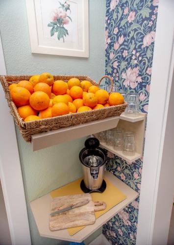 a basket of oranges on a shelf in a kitchen at T H E BERLIN Studios and Suites in Nea Vrasna