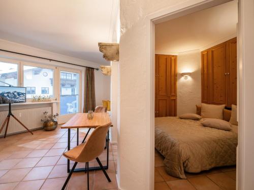 a bedroom with a bed and a table in a room at Ferienwohnungen Egger in Hopfgarten im Brixental