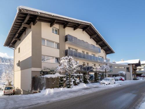 a building in the snow with cars parked in front at Ferienwohnungen Egger in Hopfgarten im Brixental