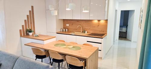 a kitchen with a wooden table and a sink at Superior Apartment Lisinski - Private parking - 2 & 3 Bedroom in Zagreb