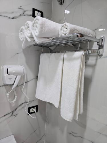 a towel rack in a bathroom with white towels at Hotel Aleks in Shkodër