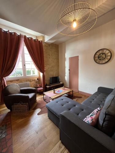 una sala de estar con un sofá y una mesa en Le Pink Lady Appartement centre historique de Bergerac, en Bergerac