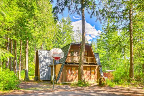 a house in the woods with a basketball hoop at Rhododendron Retreat with Hot Tub Steps to River! in Rhododendron