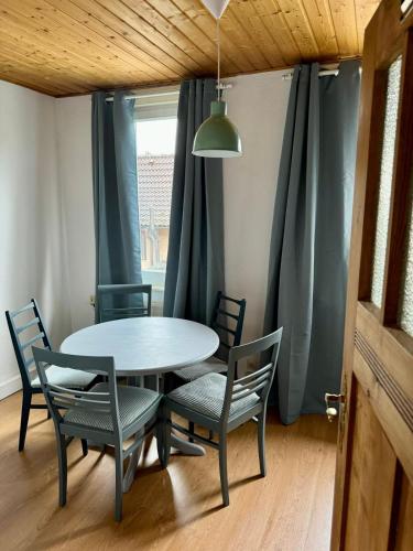 a table and chairs in a room with a window at Leopold's Apartments mit Garten und Vesteblick Mitten in Coburg in Coburg