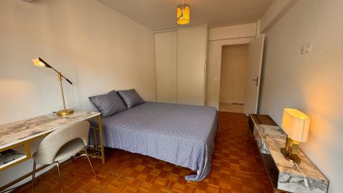 une chambre avec un lit et un bureau avec une lampe dans l'établissement Élégant 3 pièces, 2 chambres, 4 pers, clim, Wi-fi, proche des plages, à Nice