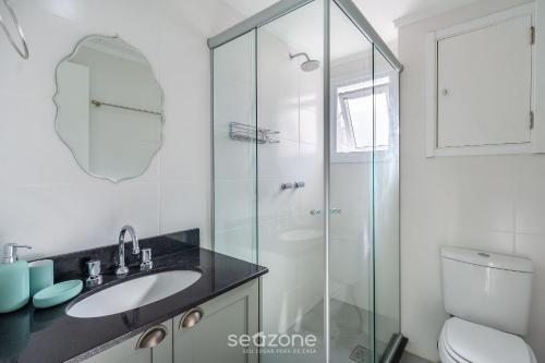 a bathroom with a sink and a glass shower at Studio encantador e bem localizado PoA-RS VENB504 in Partenon