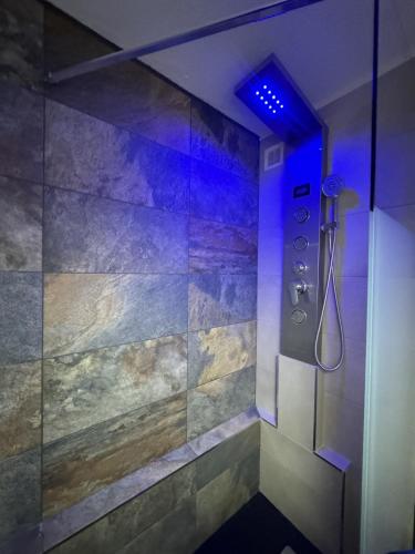 La salle de bains est pourvue d'une douche avec une lumière bleue. dans l'établissement Appartement - Cap d'Agde, au Cap d'Agde