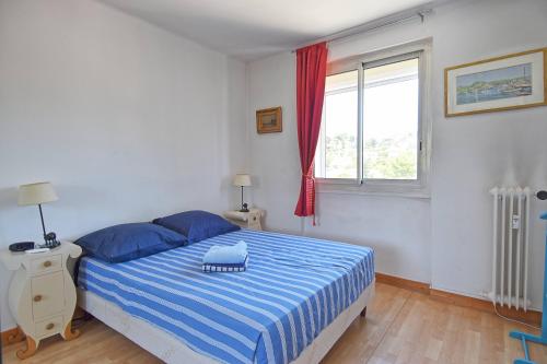 - une chambre avec un lit bleu et blanc et une fenêtre dans l'établissement Grand T2 avec une magnifique vue mer et JO, à Marseille