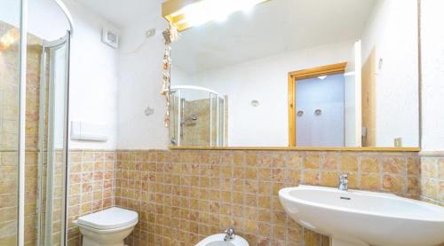 a bathroom with a sink and a toilet and a mirror at VALENTINA HOME Costa Smeralda Vista Mar in Cugnana Verde