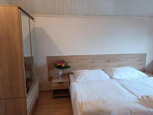 a bedroom with a white bed and a vase of flowers at Ardilla in Lhota