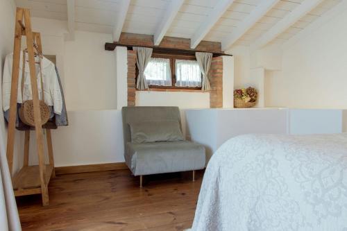 a bedroom with a bed and a chair and a window at El Molino de Bonaco in San Vicente de la Barquera