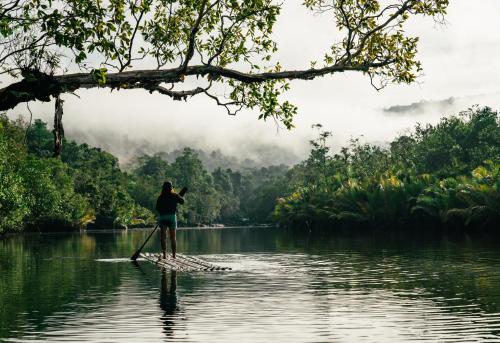 a person on a paddle board in the water at Thansur Tatai Eco Resort in Tatai