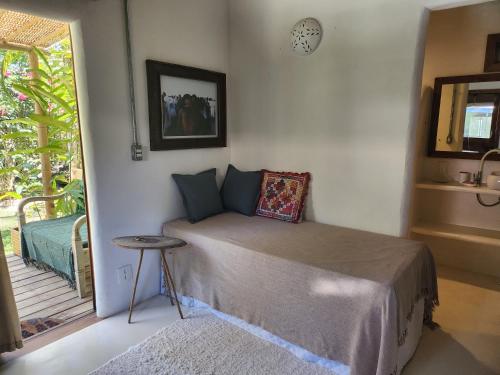 a bedroom with a bed and a table in it at Suíte Caju - Conforto e Exclusividade em Trancoso in Trancoso