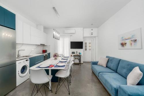 a living room with a blue couch and a table at Aphrodites Place in Messini