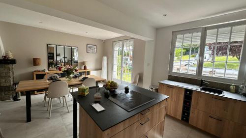 une cuisine avec évier et table ainsi qu'une salle à manger dans l'établissement Maison de Tara à la mer, à Étaples