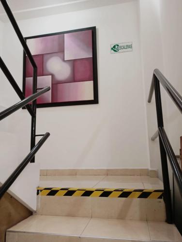 a staircase with a sign on the wall and a painting at Hotel San Diego DOSQUEBRADAS in Dosquebradas