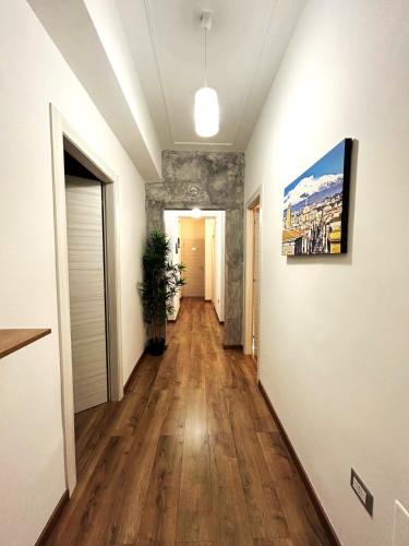 a hallway of an apartment with wooden floors and a painting on the wall at EFFE Home in Catania