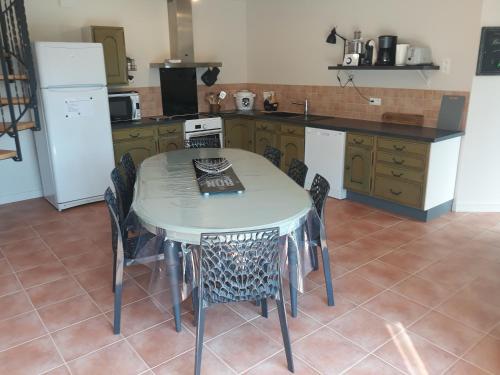 a kitchen with a table and chairs in a kitchen at Gite de la Houssière in Joué-du-Bois