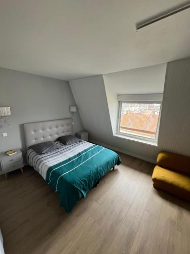a bedroom with a bed and a window at Duplex Fossorier - BALCON CENTRE VILLE - in Deauville