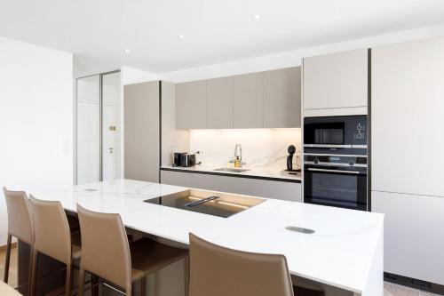 une cuisine blanche avec une grande île blanche et des chaises dans l'établissement Carlton area lux 2 beds 2 baths, à Cannes