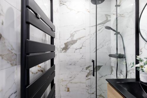 La salle de bains est pourvue d'une douche et d'une porte noire. dans l'établissement Carlton area lux 2 beds 2 baths, à Cannes