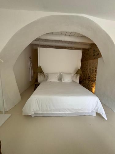 - une chambre avec un lit blanc et une voûte dans l'établissement La Maison de Victor, à La Bruguière