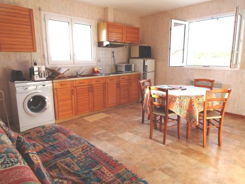 une cuisine et une salle à manger avec une table et une table et des chaises dans l'établissement APPARTEMENT MER du samedi au samedi, à Saint-Georges-de-Didonne