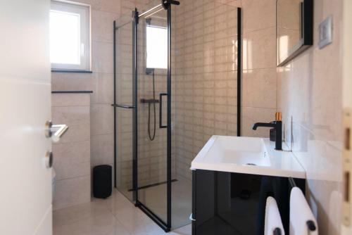 a bathroom with a sink and a shower at Two bedroom apartment Karmen with pool in Sinj