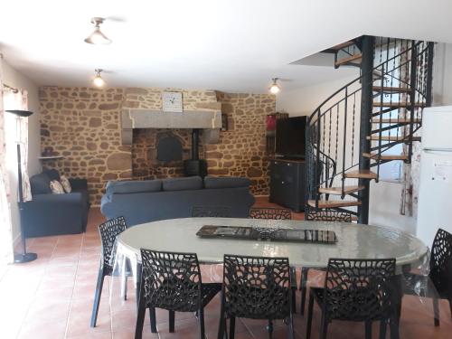 a living room with a table and chairs and a couch at Gite de la Houssière in Joué-du-Bois