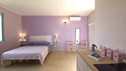 a bedroom with a bed and a purple wall at Agriturismo Le Terre di Veneré in Acciaroli