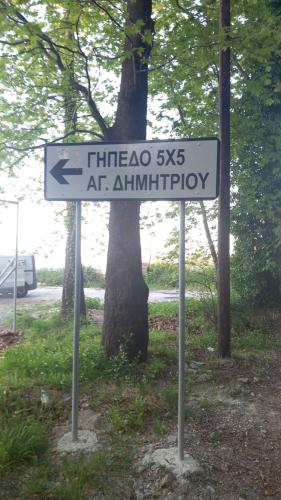 a street sign in front of a tree at Paradeisos Rooms Pelion in Agios Dimitrios