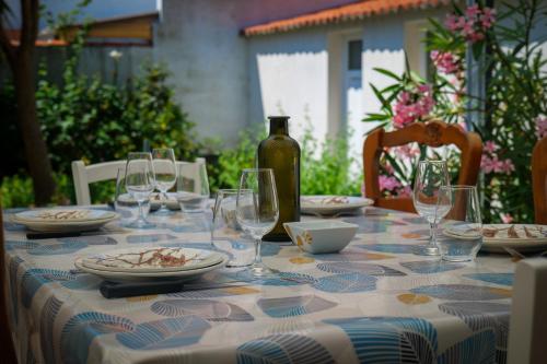 - une table avec des verres, des assiettes et une bouteille de vin dans l'établissement Maison de vacances quartier Arago Les Sables - 6 personnes, à Les Sables-dʼOlonne