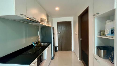 a kitchen with a sink and a refrigerator at Pixel - Studio Cape Panwa Ocean Front Partial Seaview in Ban Ao Makham
