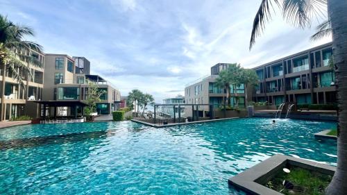 a large pool with blue water in front of buildings at Pixel - Studio Cape Panwa Ocean Front Partial Seaview in Ban Ao Makham