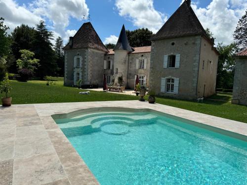 un domaine avec une piscine en face d'un bâtiment dans l'établissement Chateau La Rochette, à Lisle