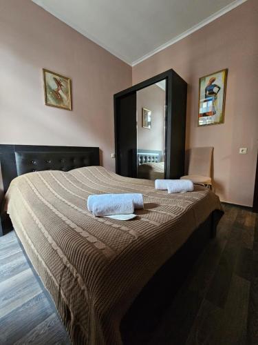 a bedroom with a large bed with two towels on it at Comfy Nook Apartment in Tbilisi City