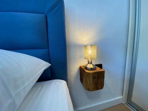 a lamp on a table next to a bed at Dalmatia Nin apartment in Nin