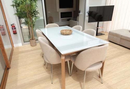 a white dining table and chairs in a living room at HOMELIKE FUNCHAL II in Funchal