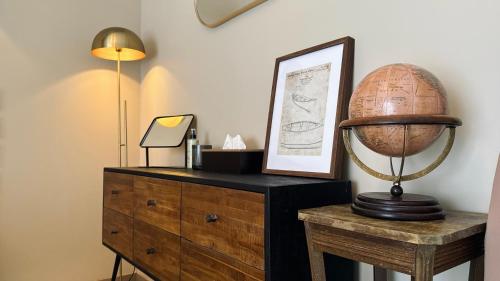 a room with a dresser with a globe on top of it at Domaine Kaet in Ratenelle