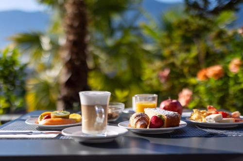 a table topped with plates of food and drinks at Easy Stay by Hotel La Perla in Ascona