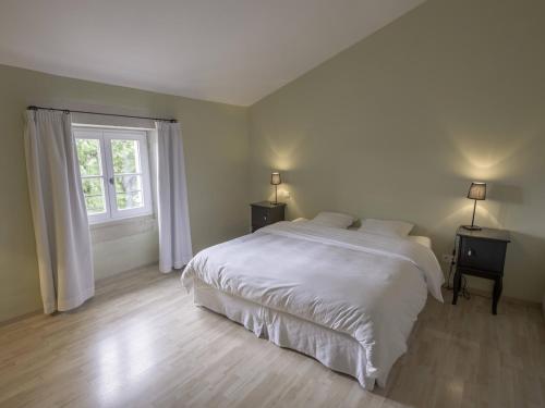 a bedroom with a white bed and a window at Est in Colonzelle