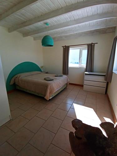 a bedroom with a bed and a large window at El Puente dptos in Caviahue