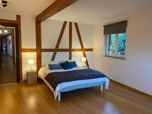 une chambre avec un lit avec deux oreillers bleus dans l'établissement Les Figuiers, à Gougenheim