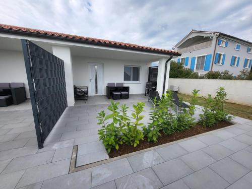 eine Terrasse eines Hauses mit einem Zaun und Pflanzen in der Unterkunft Apartman Tanja & Apartman Tea in Galižana