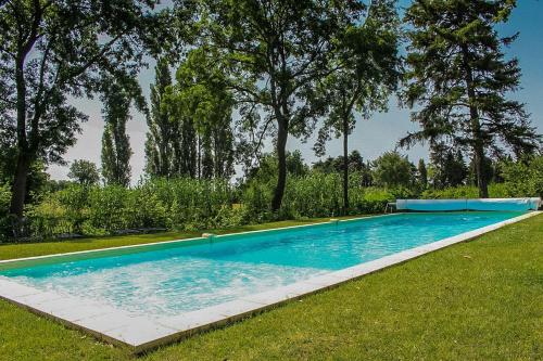 a large swimming pool in a yard with trees at Voûte in Colonzelle
