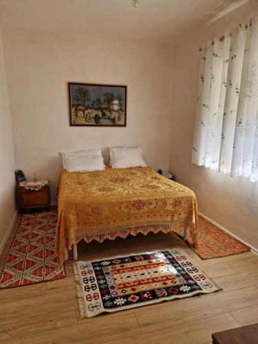 a bedroom with a bed and a rug on the floor at Guest House Vajzë S,Kasaj in Vlorë
