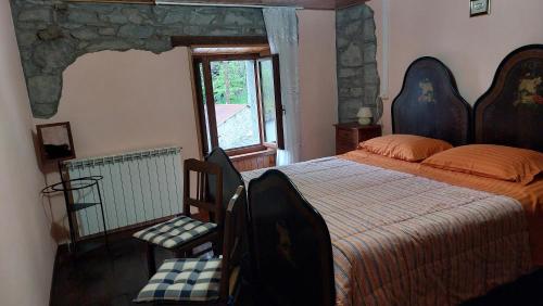 a bedroom with a large bed and a window at Casa tipica montanara in Pievepelago