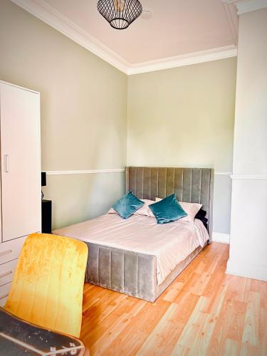 爱丁堡Wee one Flat share accomodation的卧室里有一张床，上面放着蓝色的枕头