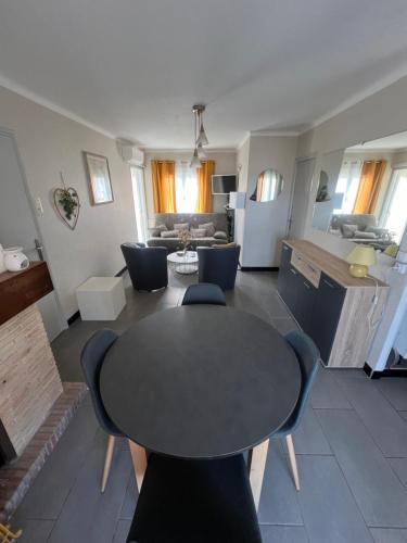 un salon avec une table et des chaises dans l'établissement Le Rascassou appartement vue sur la mer, à Narbonne
